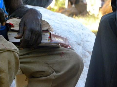 A person is holding a bible in their lap