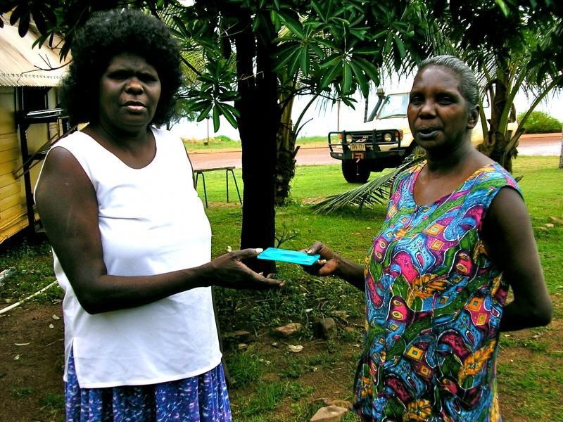 Two women are standing next to each other and one is holding something in her hand