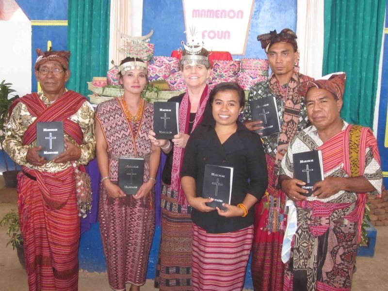 A group of people standing in front of a sign that says memenon rown