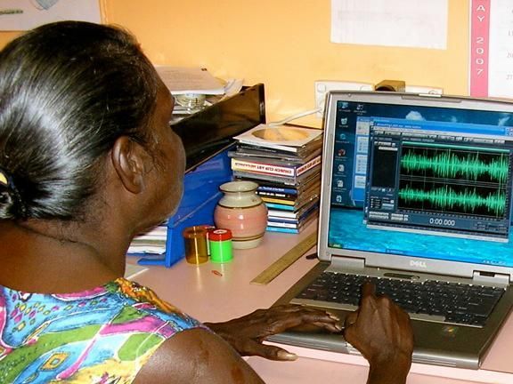 A woman is sitting at a desk using a laptop computer