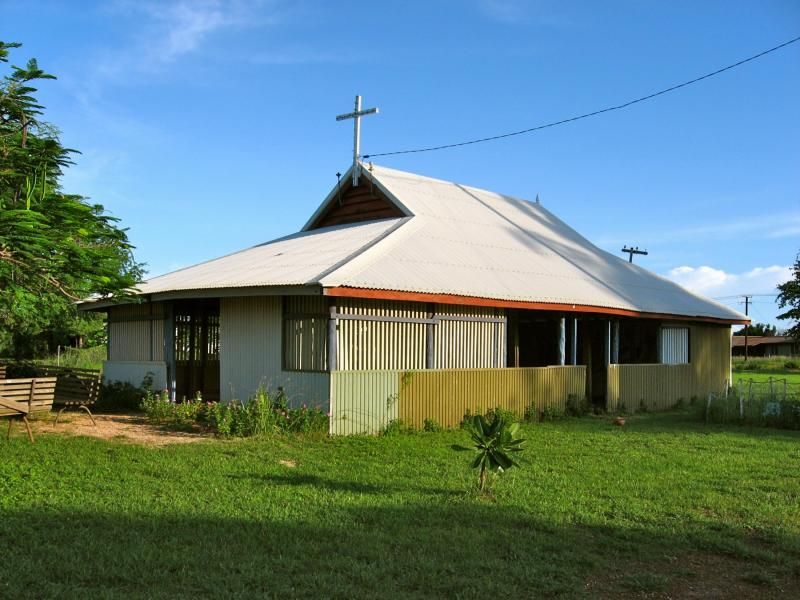 A small house with a cross on top of it