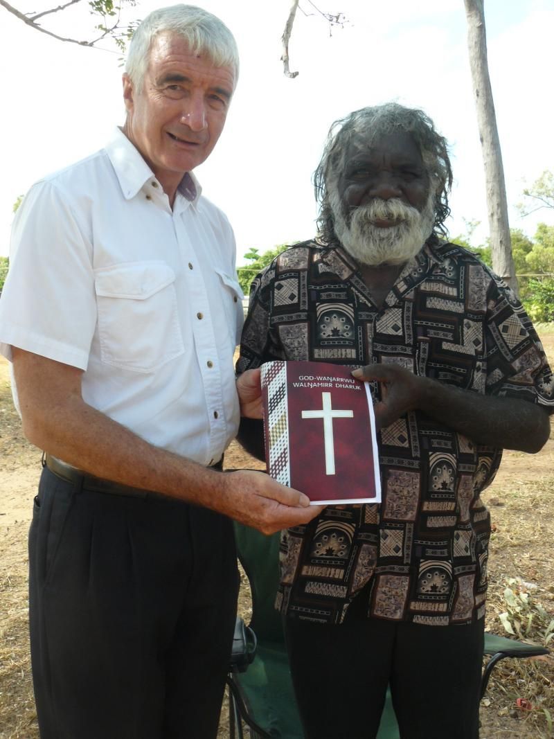 A man is holding a book with a cross on it