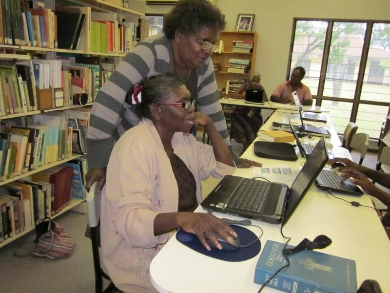 A group of people are using laptops in a library