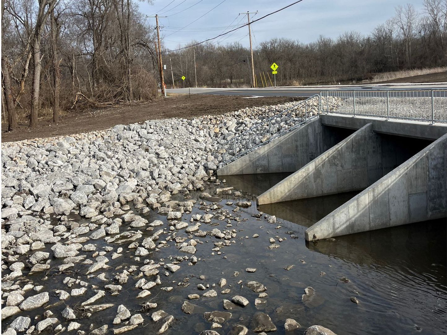 A bridge over a river with rocks on the side of it