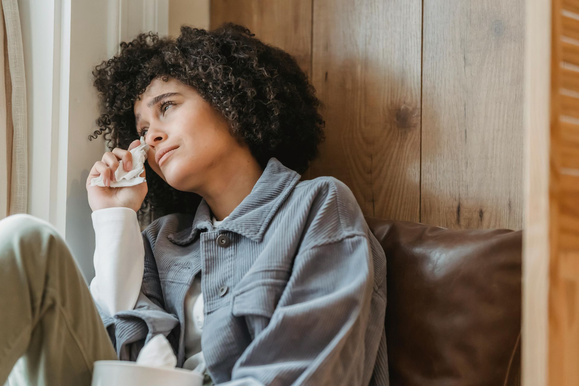 Woman sitting thoughtfully at home, reflecting on emotional impact of divorce and mental wellbeing