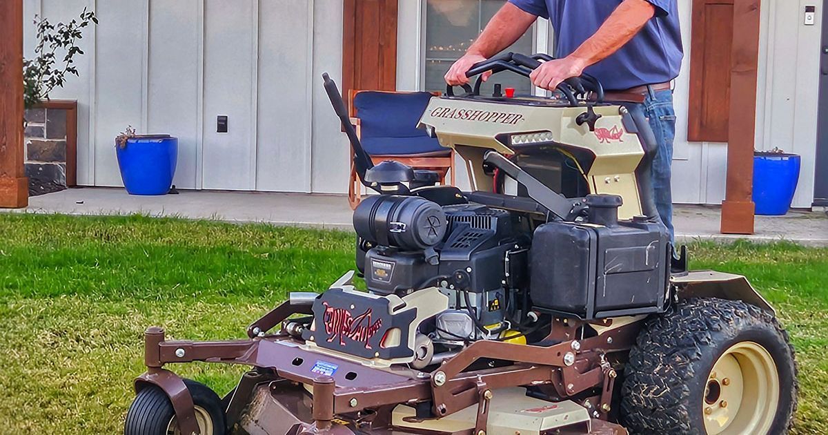 Two ECHO lawn mowers displayed in a store in front of a large ECHO brand sign.