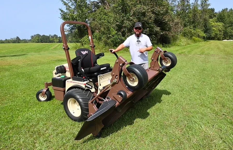 Four orange chainsaws arranged on shelves in a retail store, with red fuel cans displayed on the shelf above.