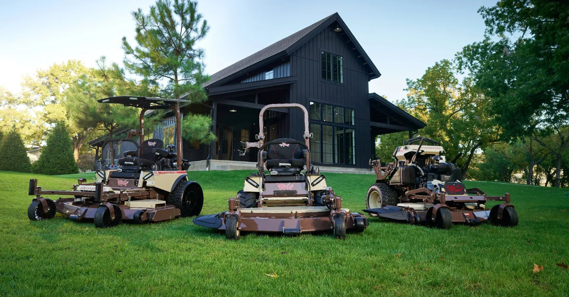 A black and orange EGO Power+ cordless lawn mower sits on a grey floor in a retail store with tools in the background.
