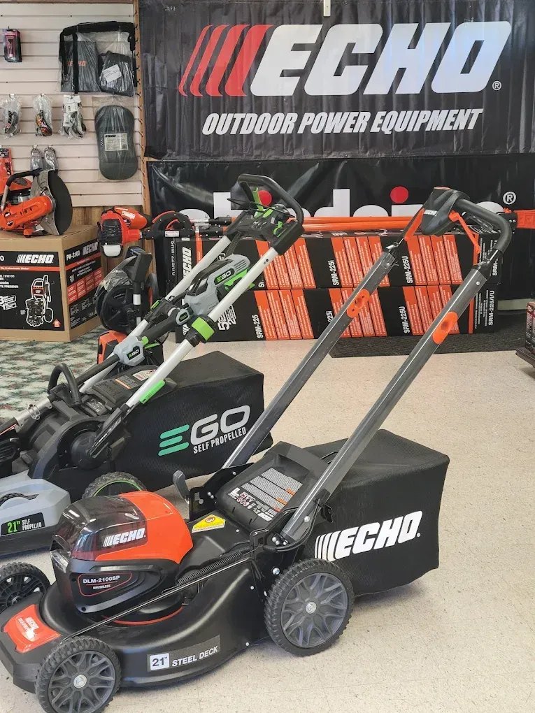 Two ECHO lawn mowers displayed in a store in front of a large ECHO brand sign.