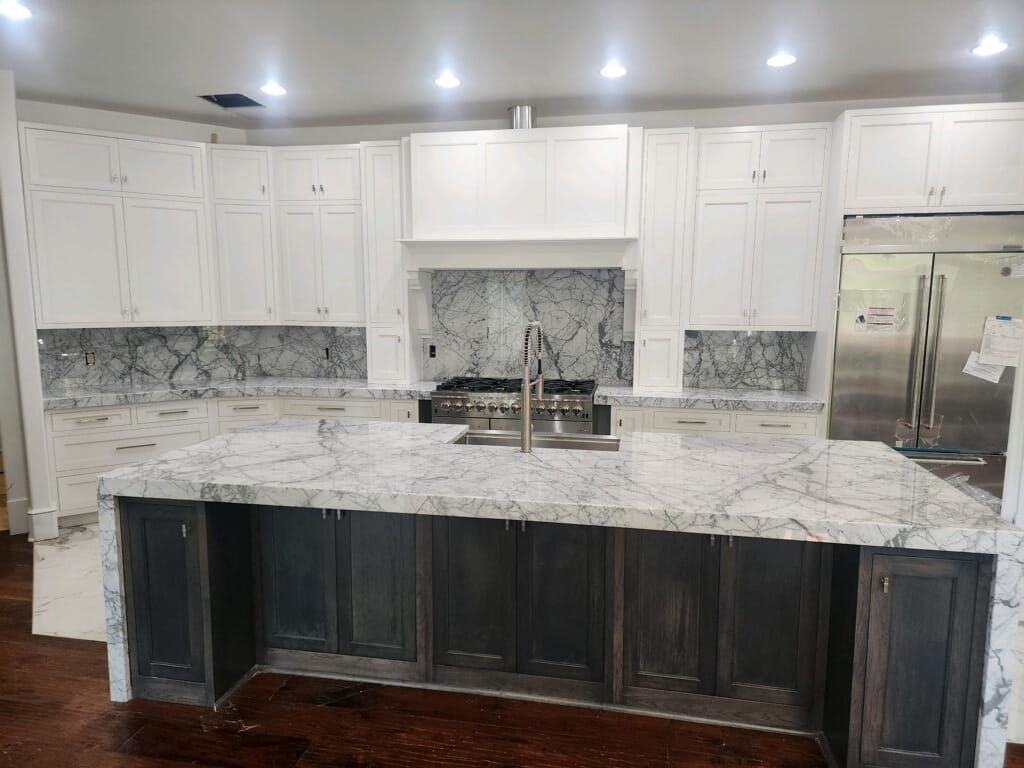 White and charcoal kitchen with granite countertops and island.