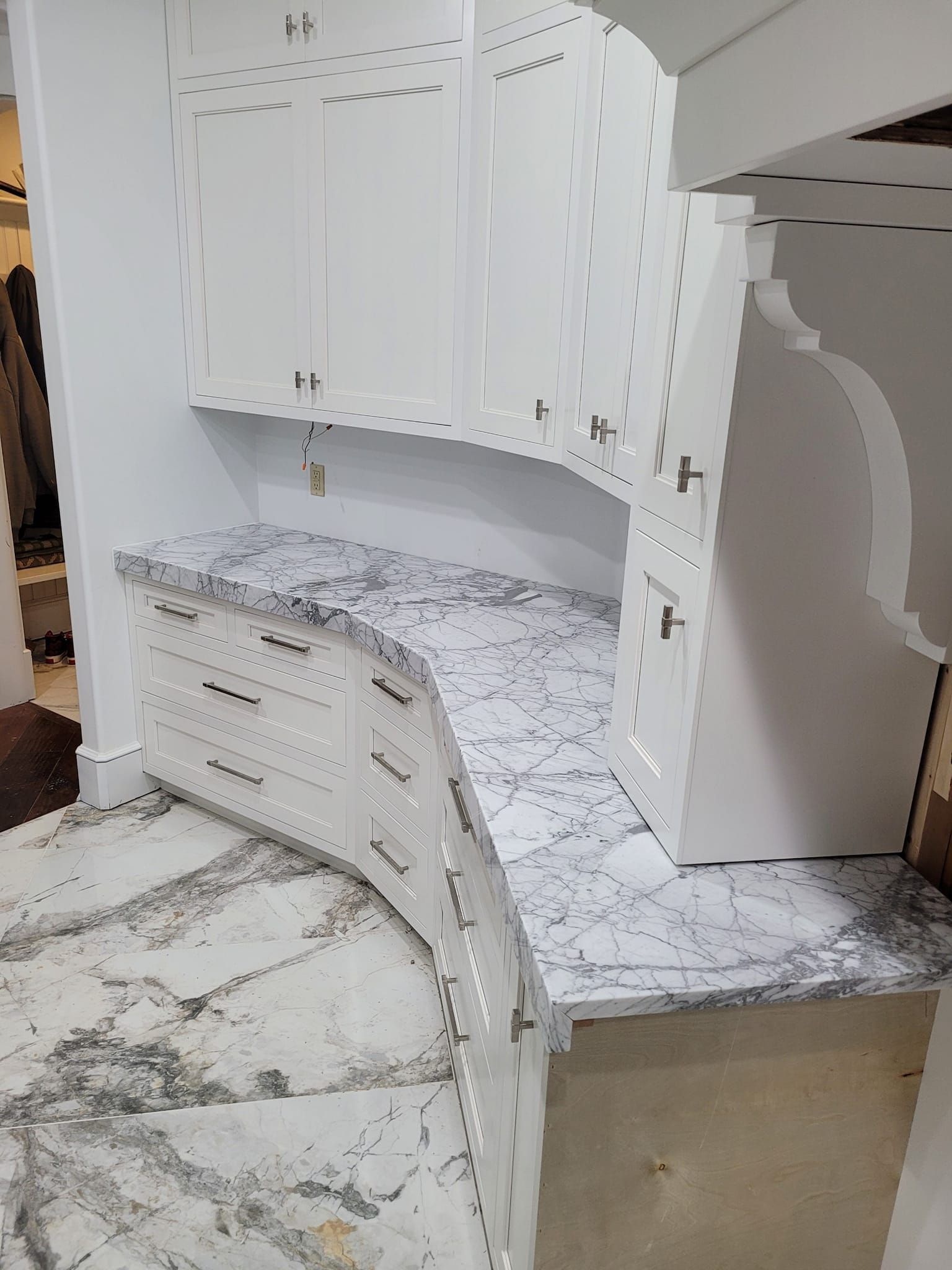 White cabinets with curved countertop, gray marble-like pattern. Kitchen remodel. White cabinets with curved countertop, gray marble-like pattern. Kitchen remodel.