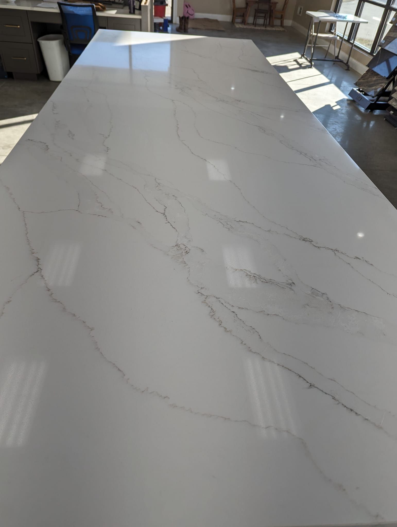 White quartz countertop with gray veining, in a sunny room.