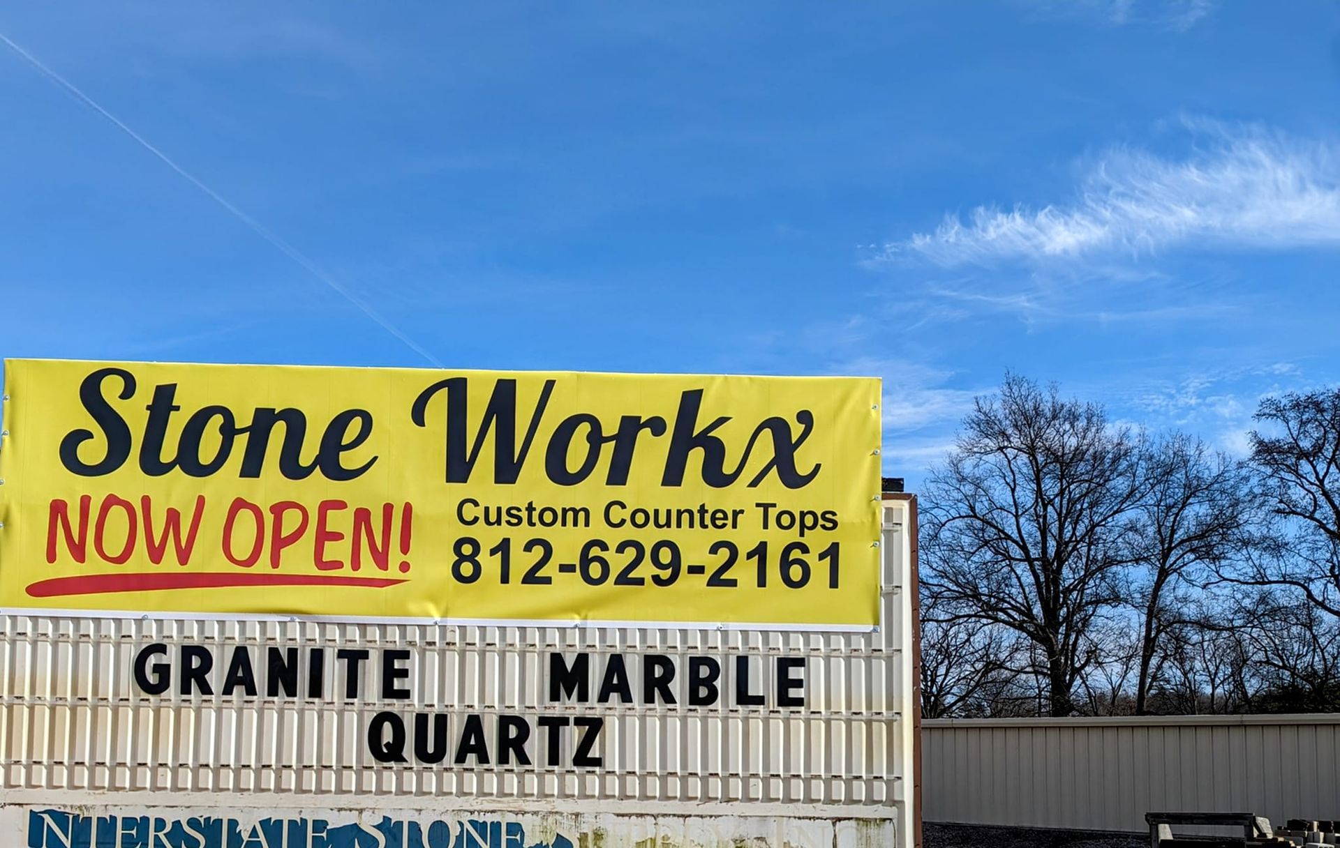 Stone Workx sign with “Now Open” in yellow; offers custom countertops in granite, marble, and quartz.