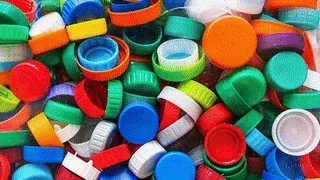 Colorful assortment of plastic bottle caps, representing recycled materials used in Brava composite roofing solutions, emphasizing sustainability and eco-friendly practices.