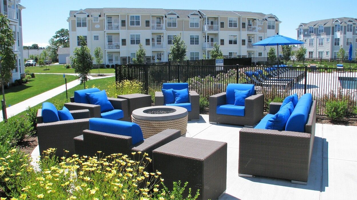 A group of chairs and a fire pit in front of a building