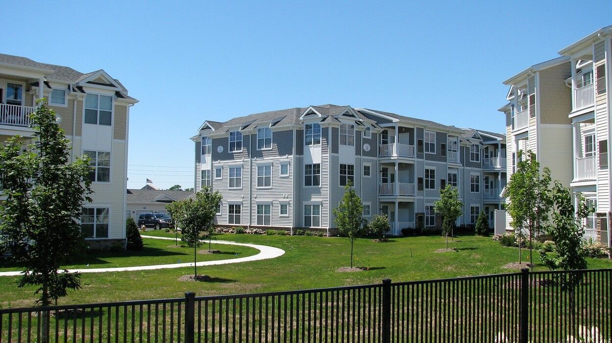 A large apartment building with a fence in front of it