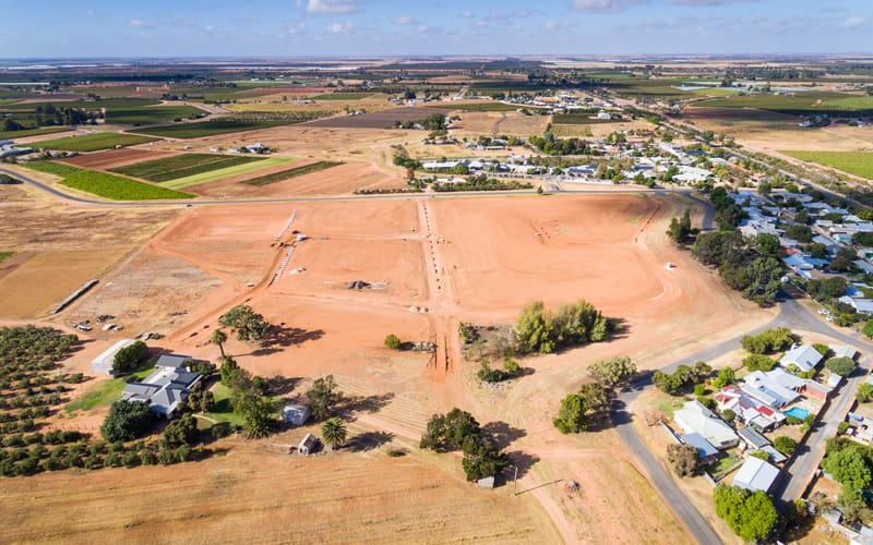 aerial view of empty land next to houses