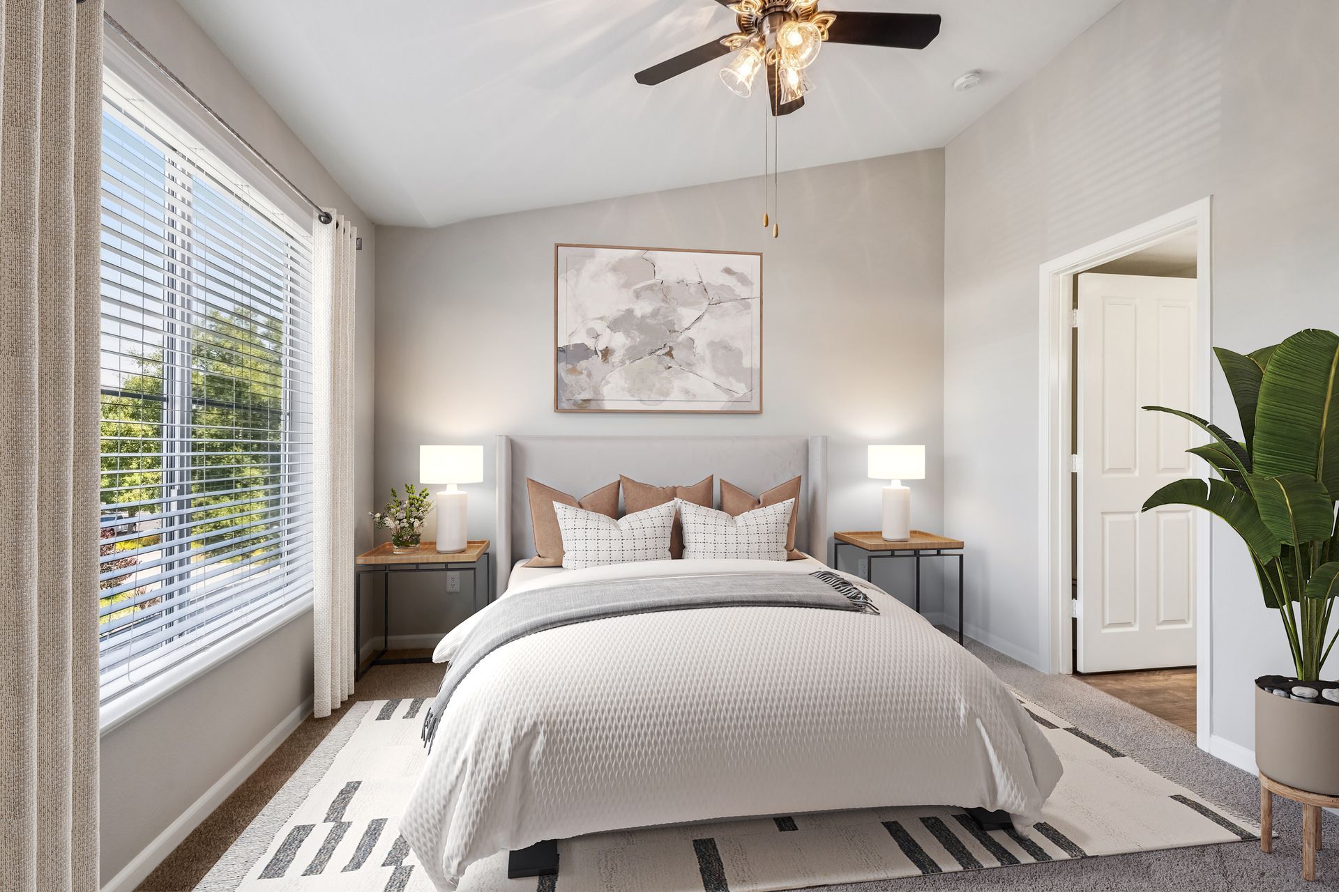 Bedroom with a bed, nightstands, window with blinds, and artwork. A potted plant stands near the door.