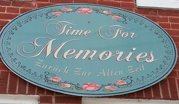 A sign on a brick wall that says time for memories