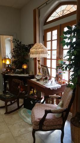 A living room with a rocking chair , table , lamp and window.