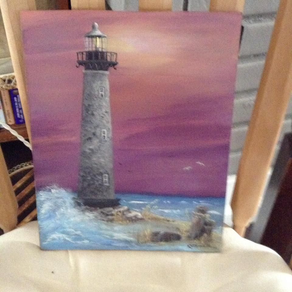 A painting of a lighthouse is sitting on a chair