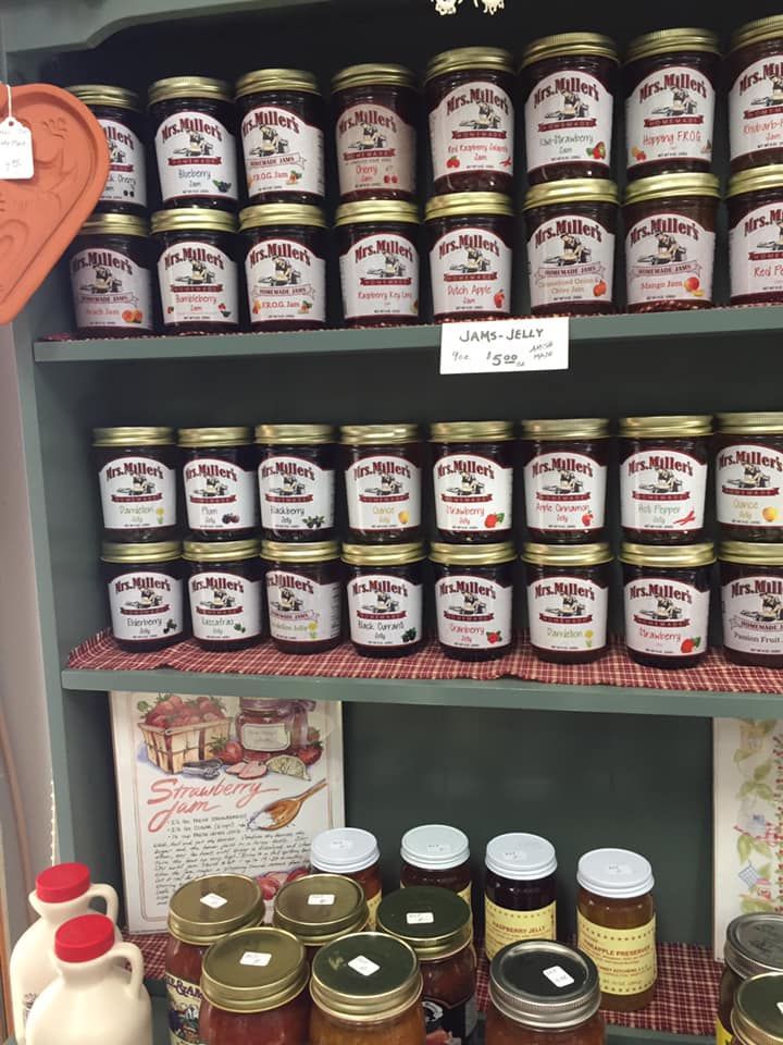 A shelf filled with jars of jam and syrup