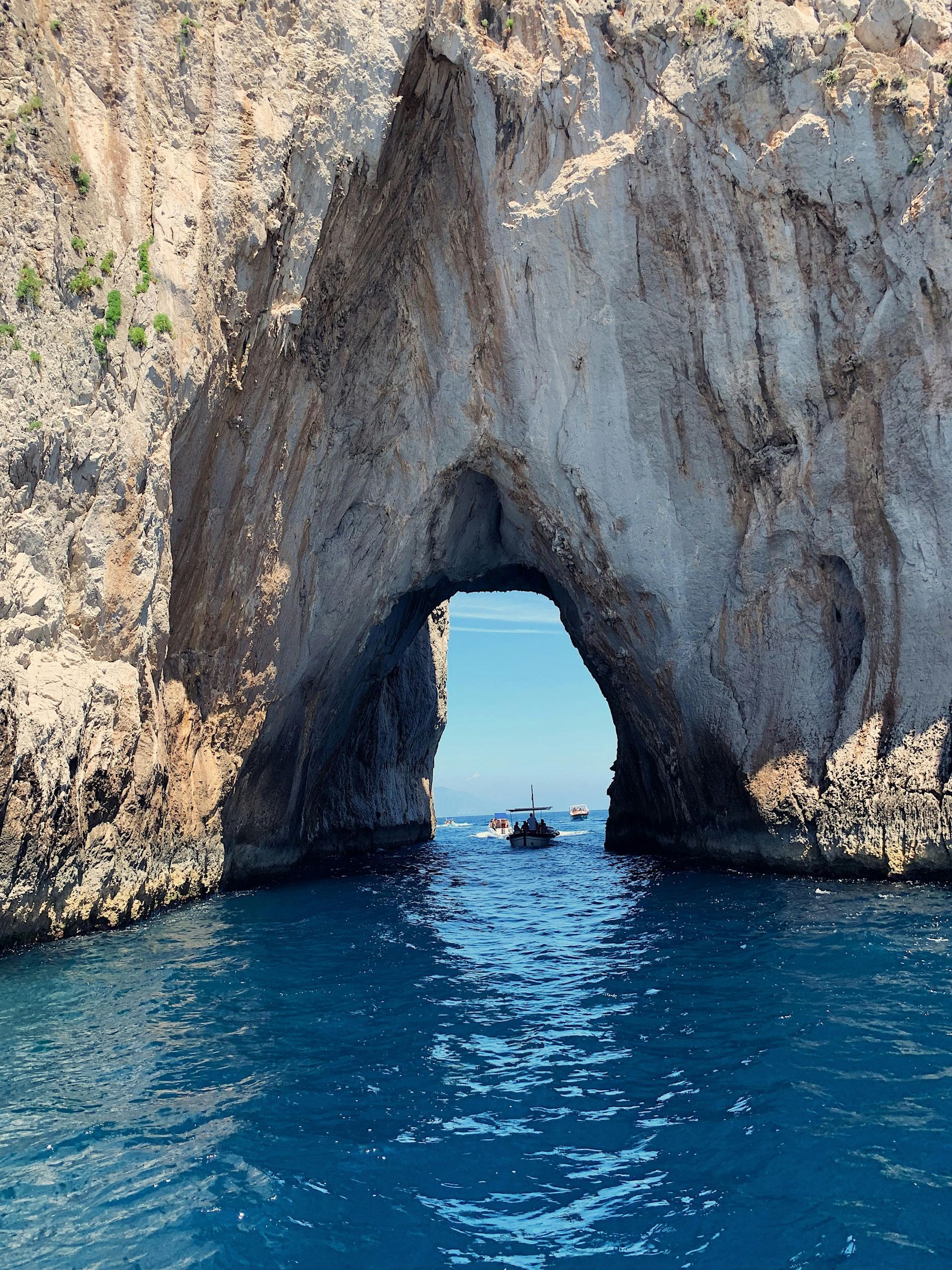 A boat is going through a cave in the ocean.