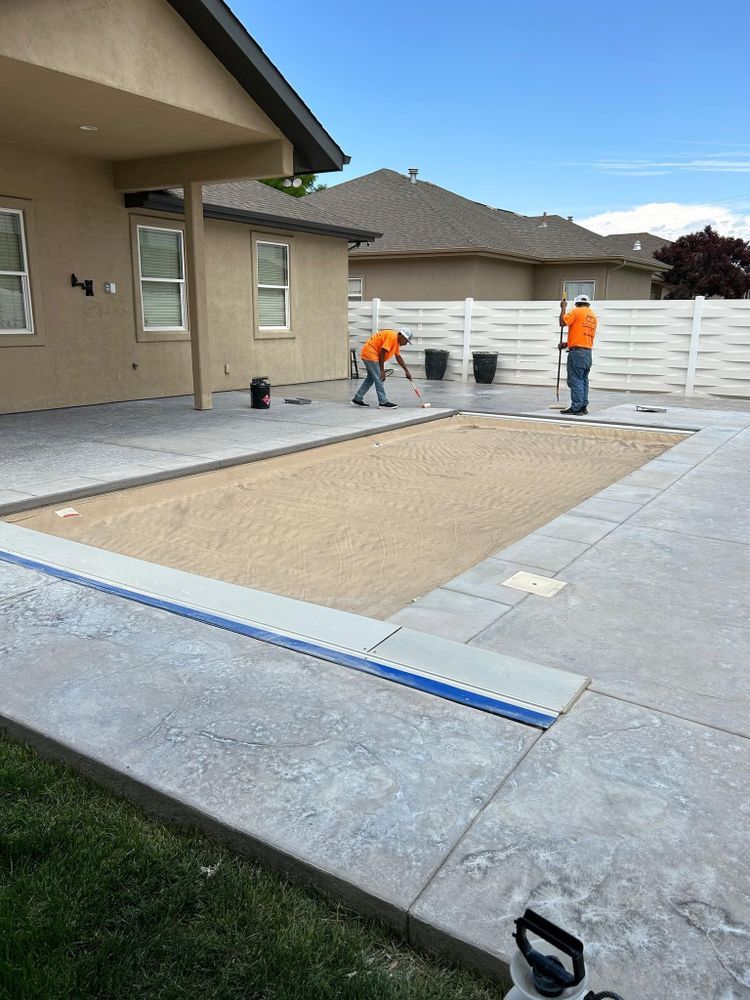 Two construction workers preparing a concrete patio.
