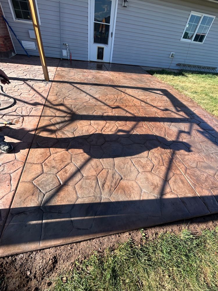 Stamped concrete patio with a decorative stone pattern in shades of brown and gray.