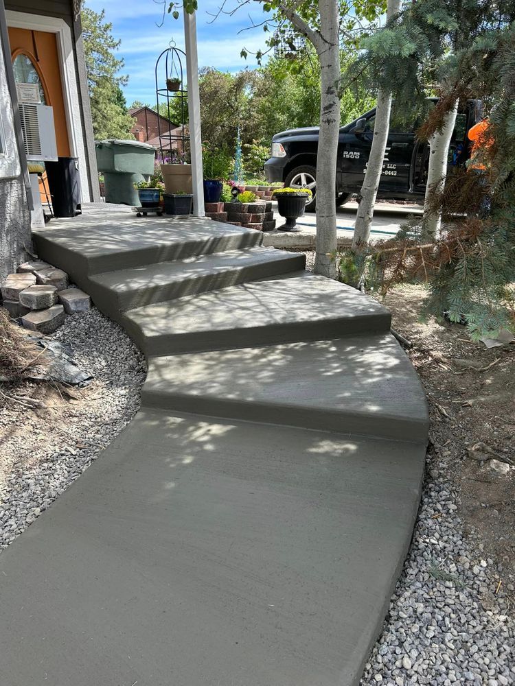 Newly poured concrete steps and walkway leading to a house, outdoor setting.