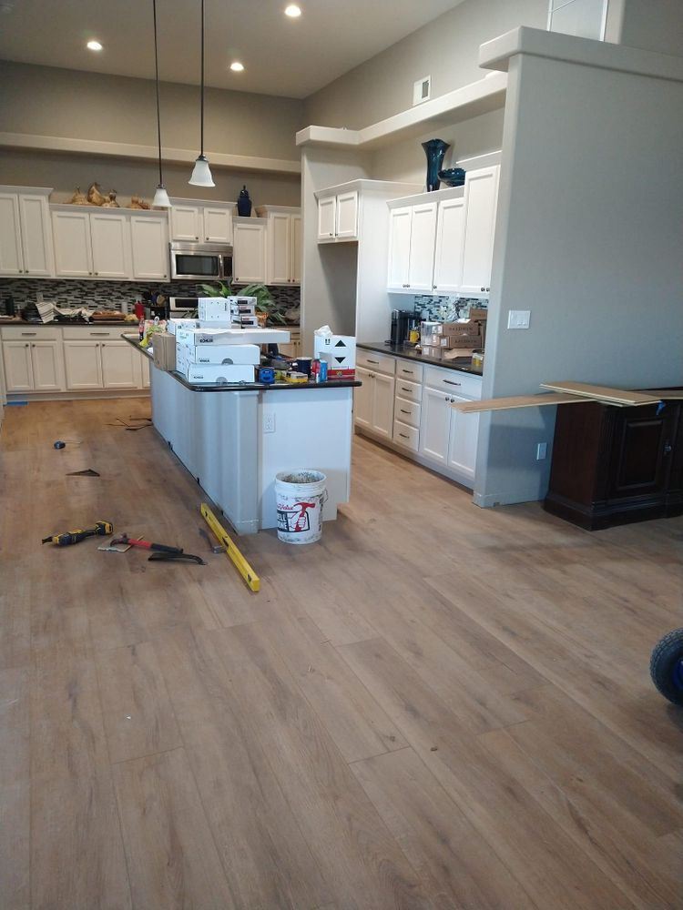 Kitchen interior with light wood flooring under construction, white cabinets and island.
