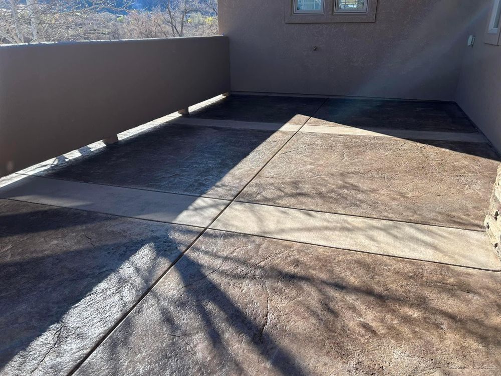 Patio with textured brown concrete floor, tan walls, and sunlight casting shadows.