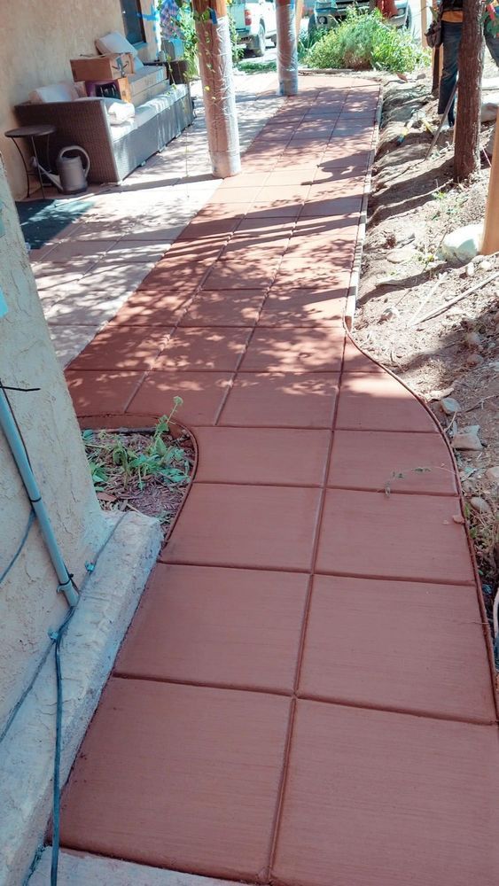Brick pathway curving from a building entrance.