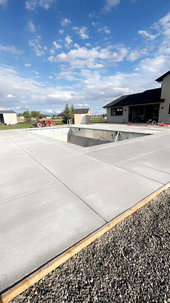 Concrete patio with an unfinished pool excavation.