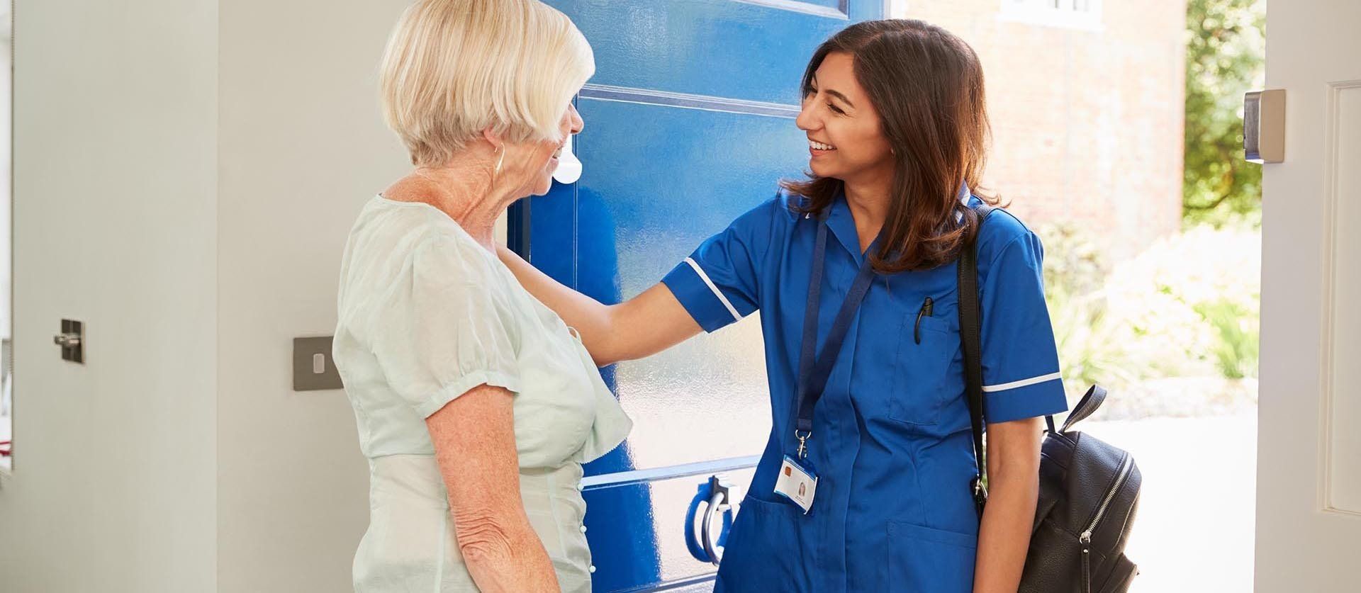 nurse helping an elderly woman in a wheelchair