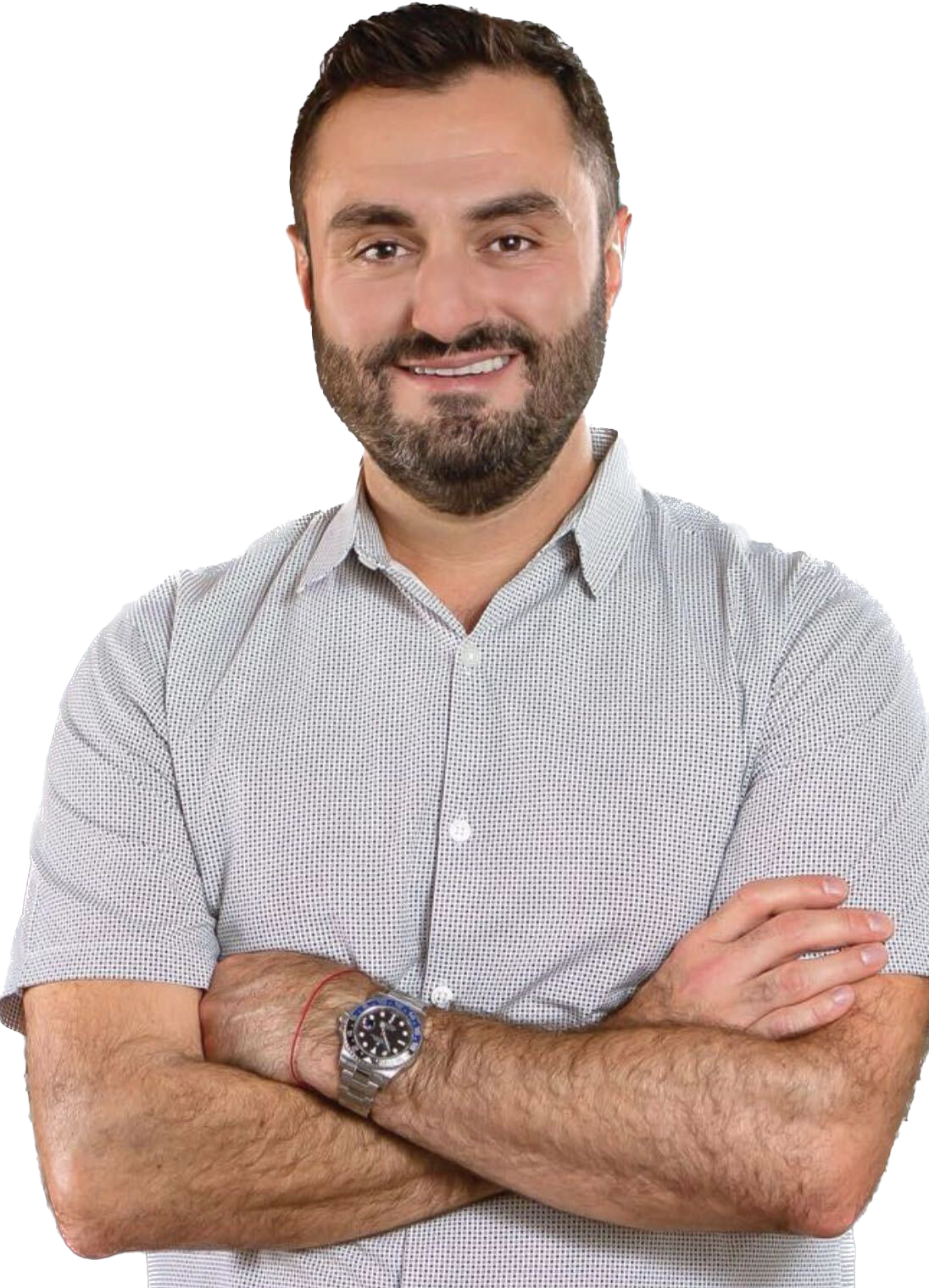 A man with a beard is standing with his arms crossed and wearing a watch.