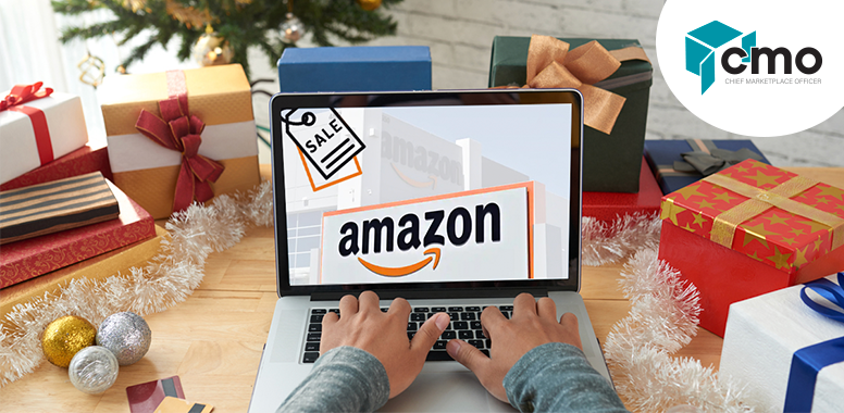 A person is typing on an amazon laptop in front of a christmas tree.