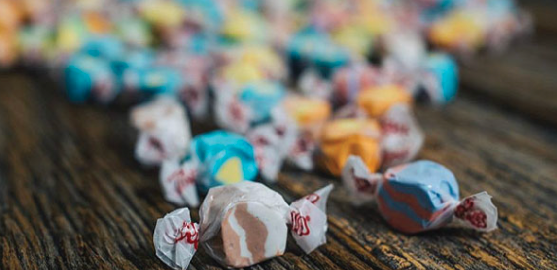 A pile of colorful taffy candies on a wooden table.