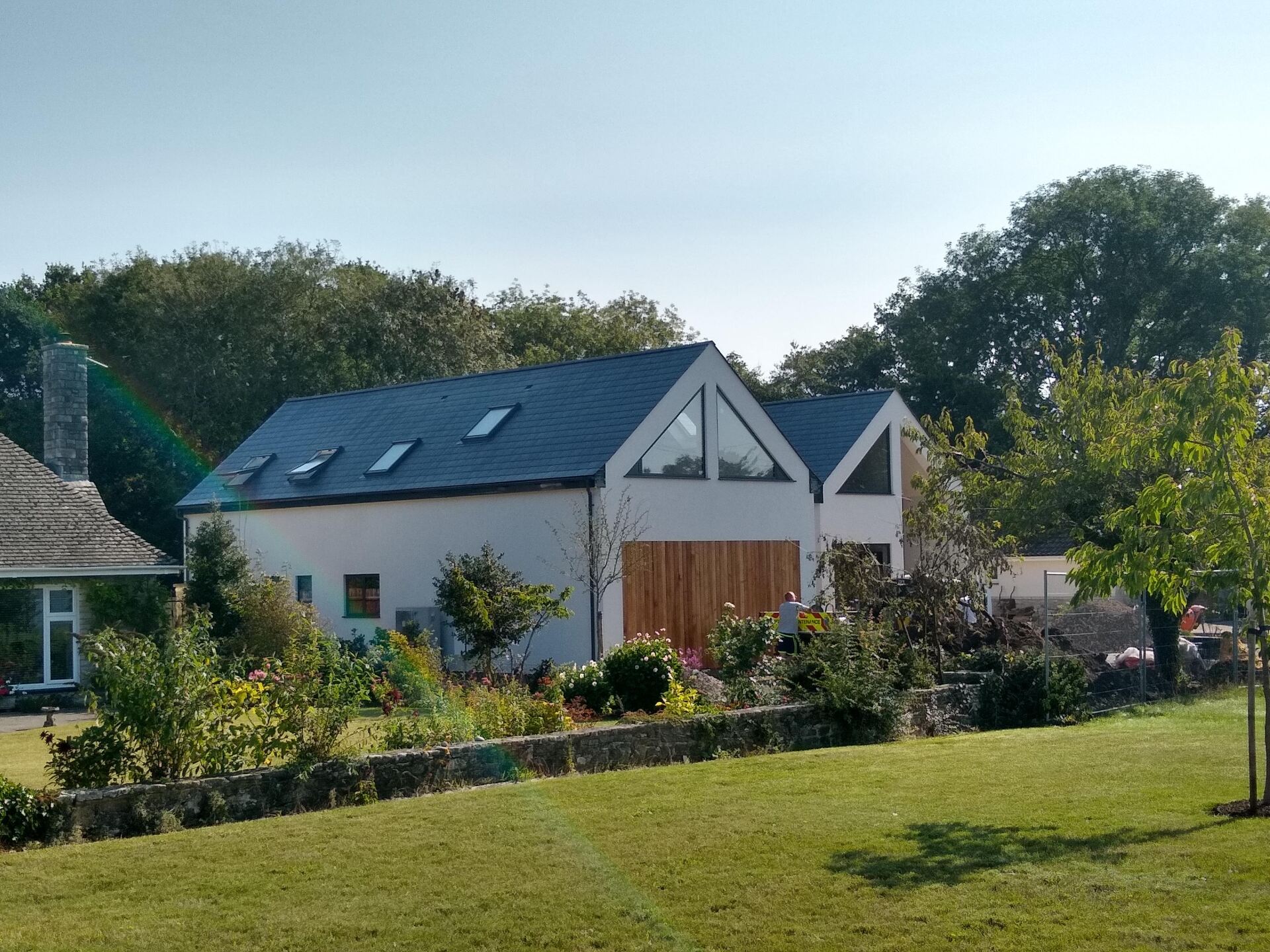 Esdon Architecture. Chalet bungalow, Ringwood, Hampshire, side view. Cedar cladding, render, bespoke triangular glazing Esdon Architecture. Wiltshire and Hampshire. New build chalet bungalow, Ringwood, Hampshire. Cedar cladding bespoke glazing.