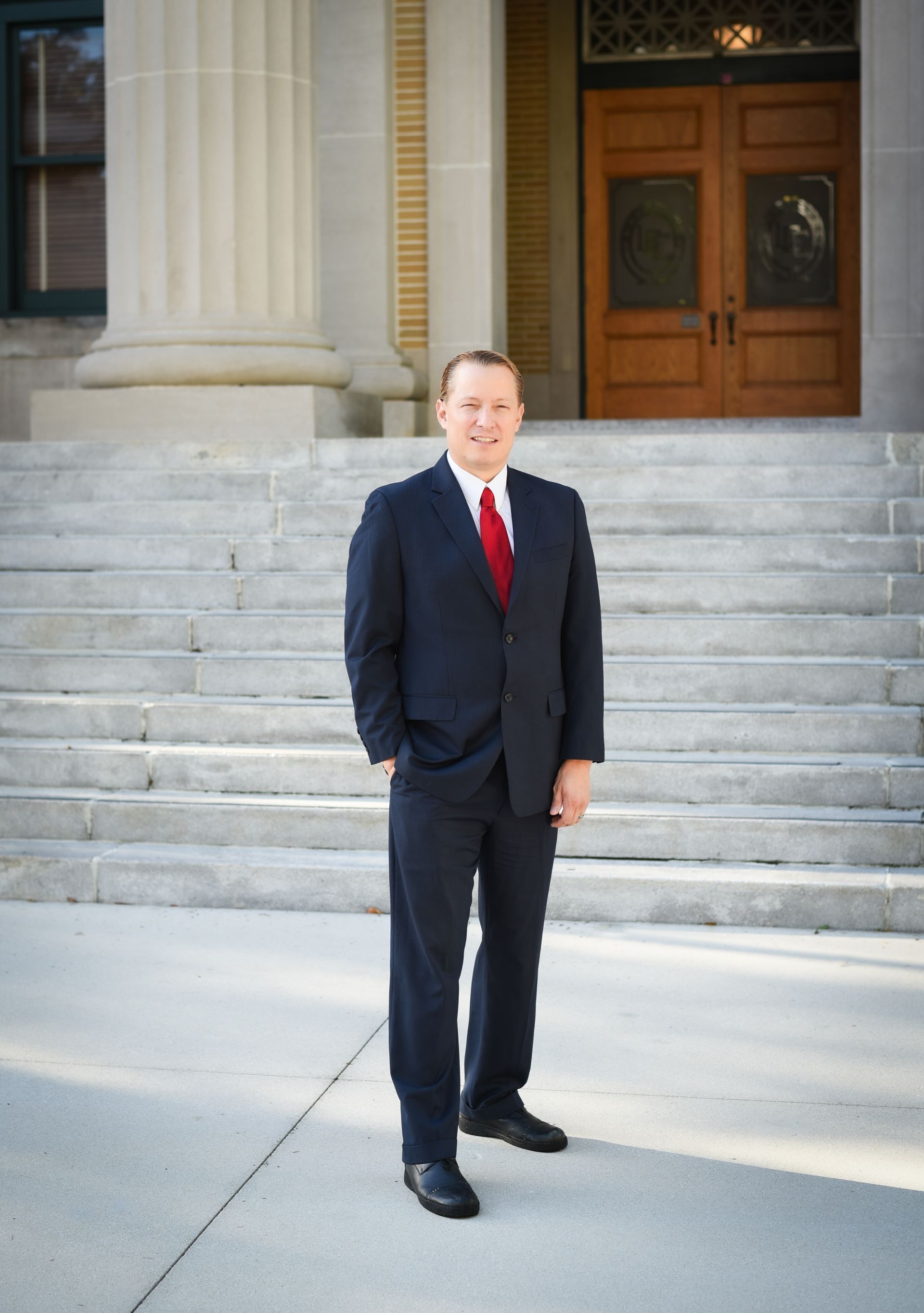 Experienced Debt and Bankruptcy Attorney Adrian Lynn stands in front of the old courthouse Fort Myer