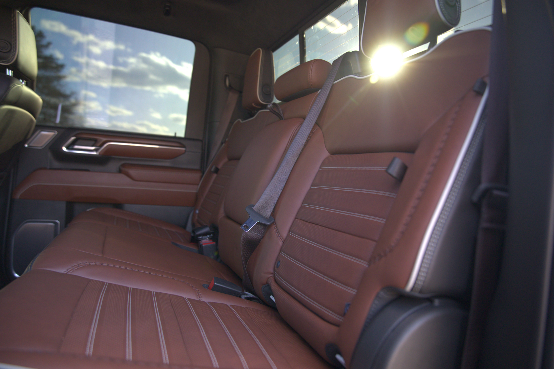 A green sports car is parked in a parking lot next to a van.