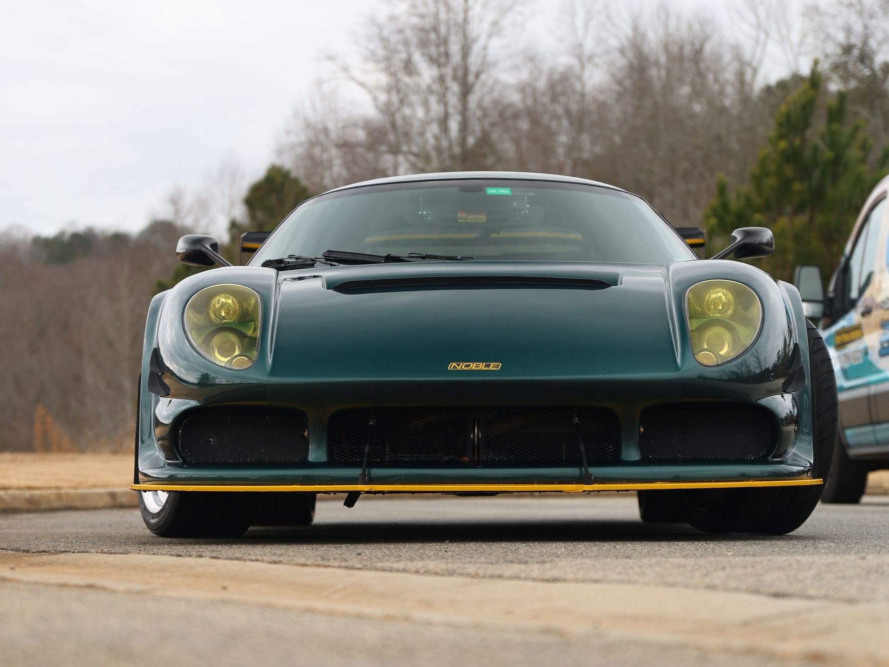 A green sports car is parked on the side of the road.