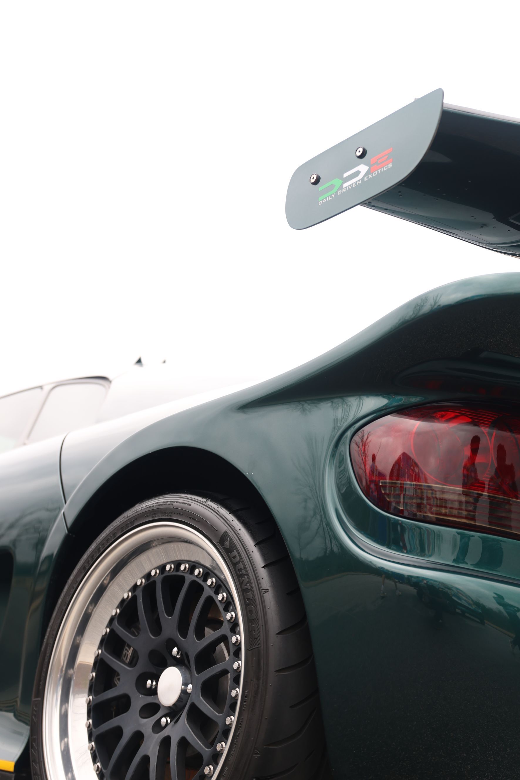 A green sports car with a spoiler on the back of it