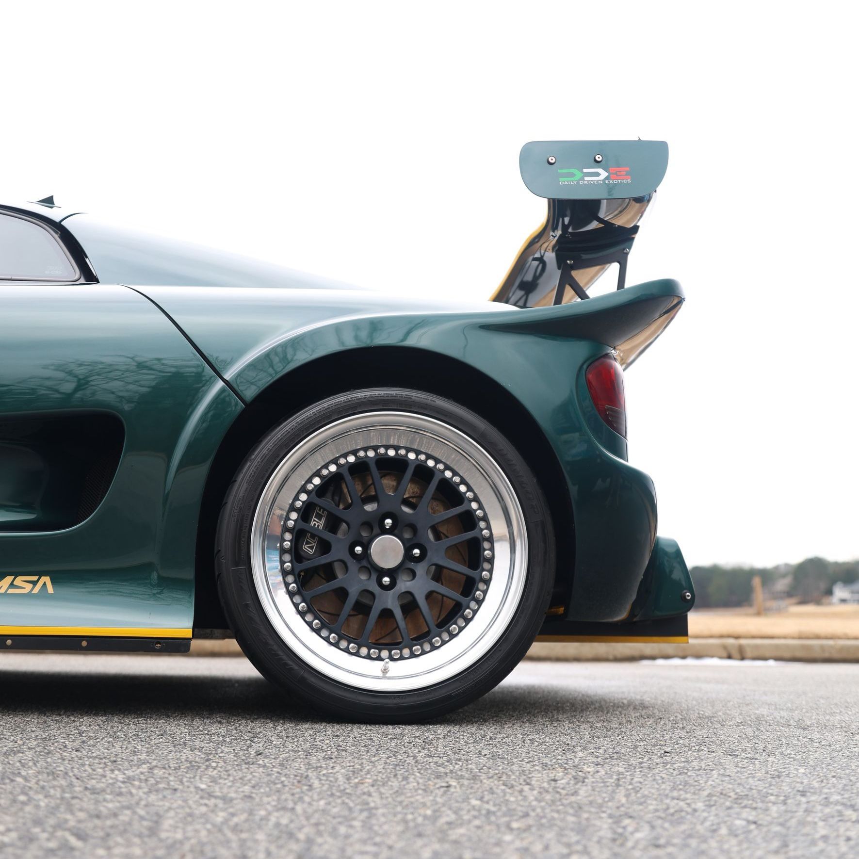 A green sports car is parked on the side of the road
