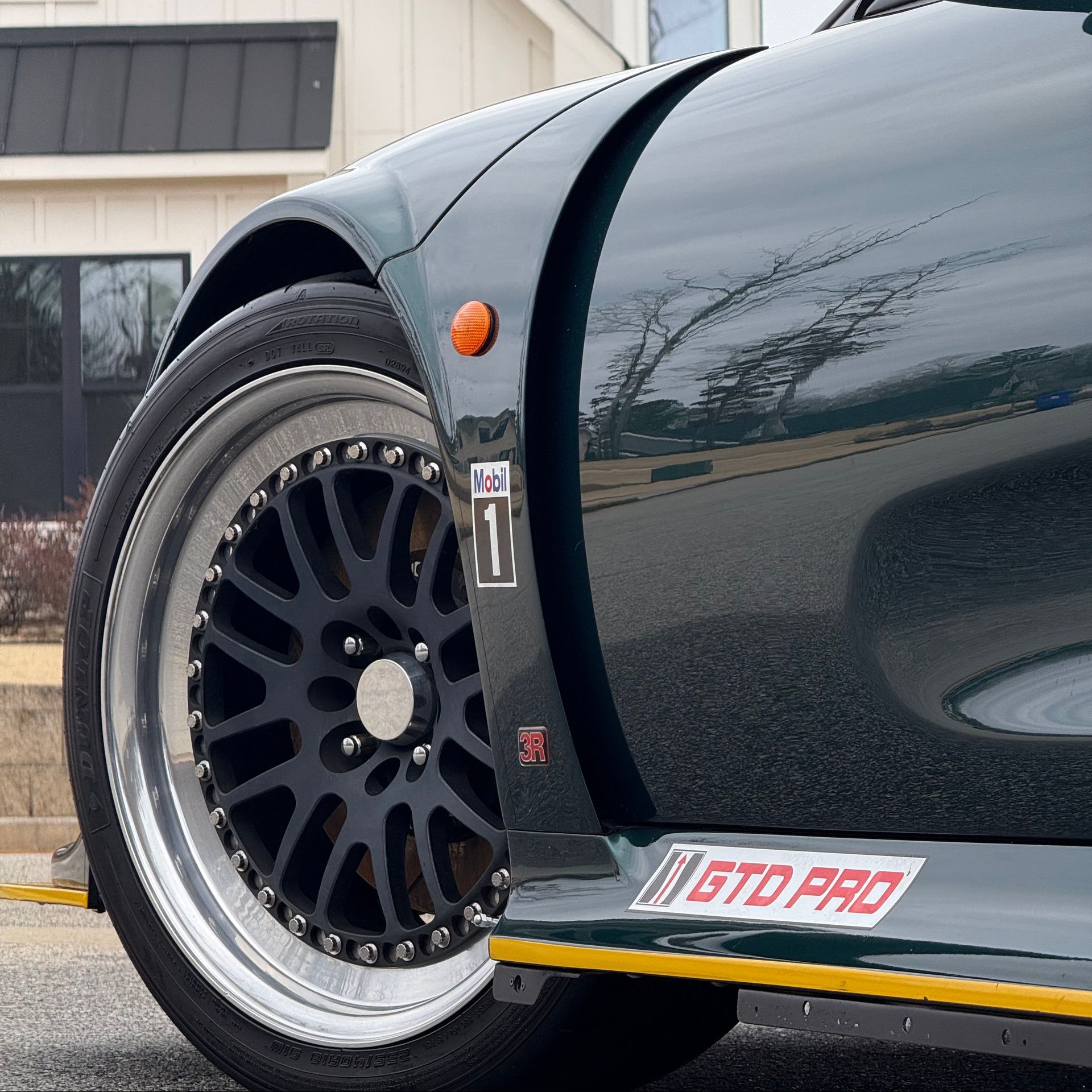 A green sports car is parked on the side of the road.