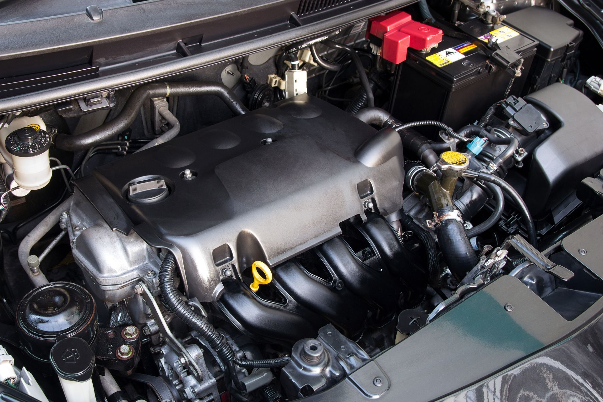 A close up of a car engine with the hood open