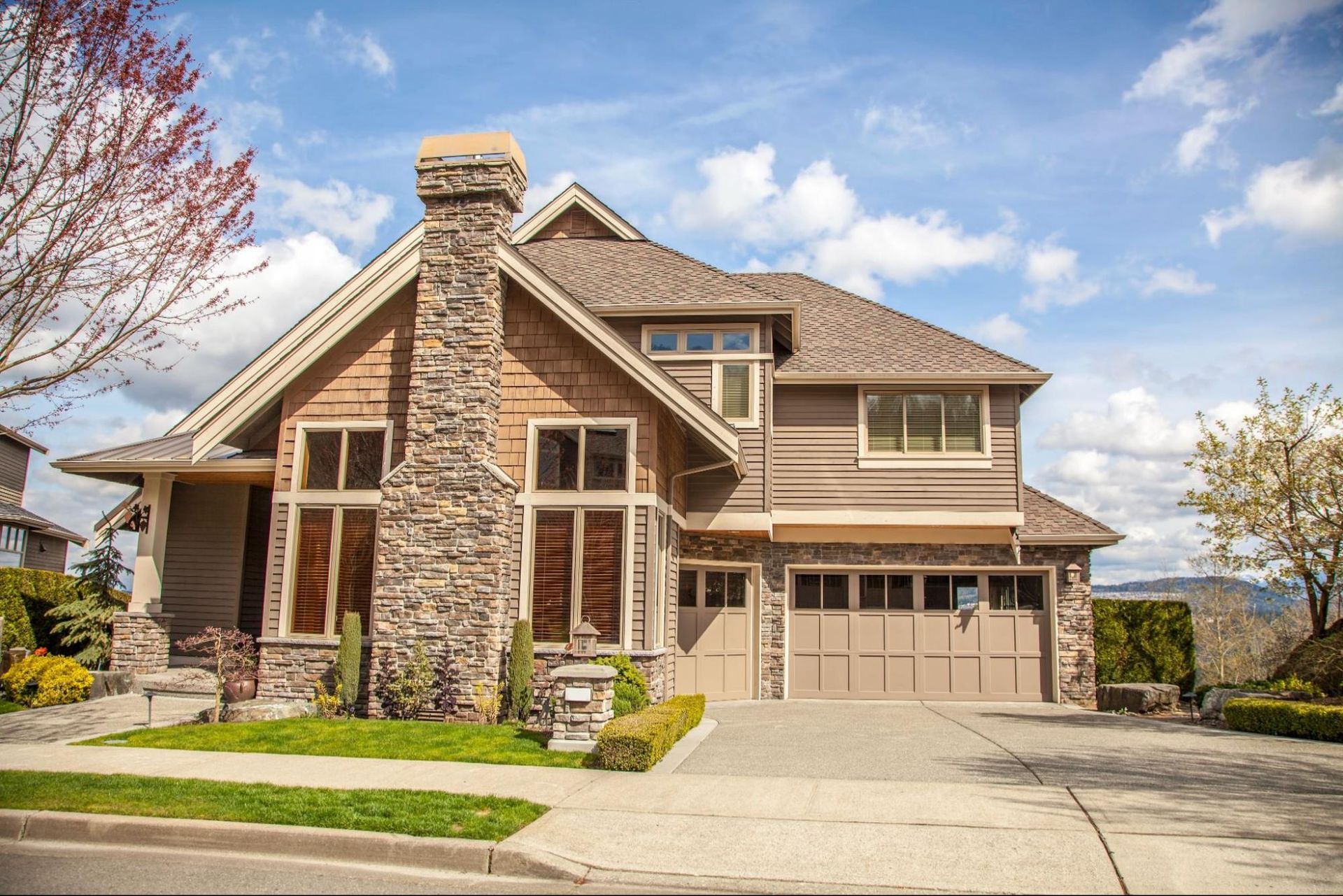 A large house with a garage and a chimney on the front of it.