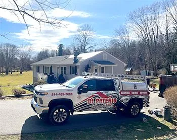 A white truck is parked in front of a house.