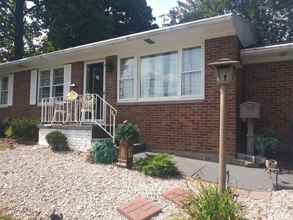 Brick house with white trim, porch, and gravel landscaping.