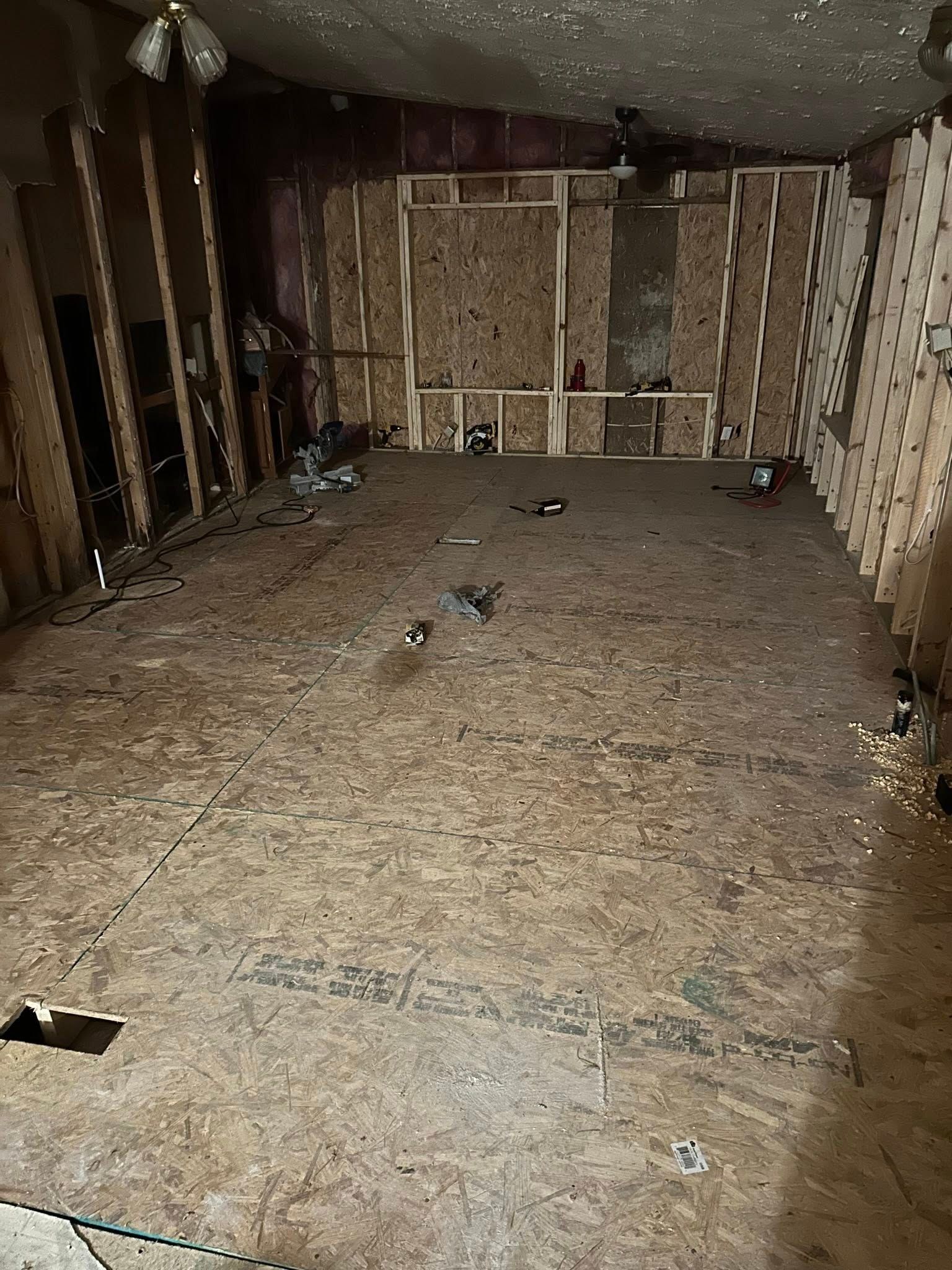 Room under construction with exposed wood framing, floor, and ceiling.